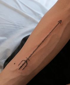 a woman's arm with an arrow tattoo on it