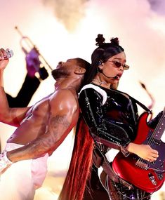 a man and woman with guitars on stage