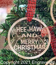 a glass ornament hanging from a christmas tree with the words she - haw and merry christmas written on it