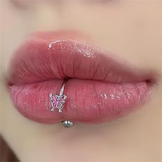 a woman's lips with pink lipstick and piercing