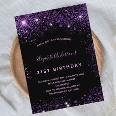 a purple and black 21st birthday party card on a wooden plate with white linens