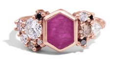 a pink ring with three different colored stones