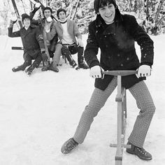 a group of people riding skis on top of snow covered ground with trees in the background