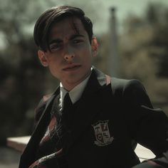 a young boy dressed in school uniform posing for the camera