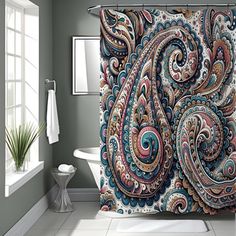 the shower curtain is decorated with colorful paisley designs and has a white bathtub in front of it