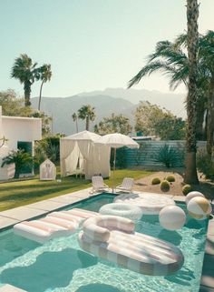 an inflatable pool with lounge chairs and umbrellas next to the swimming pool