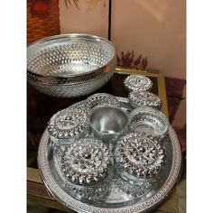 a silver plate and bowl sitting on top of a table