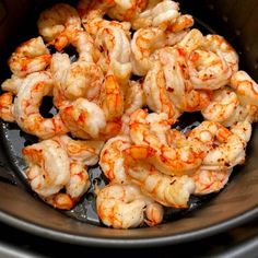 cooked shrimp in an air fryer basket ready to be cooked for dinner or lunch