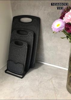 three vases sitting next to each other with flowers in the middle and one on the floor