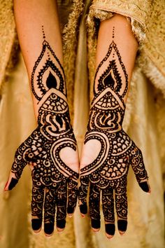 two hands with henna designs on them