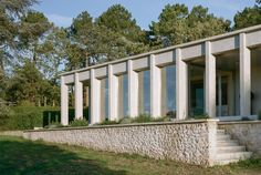 an exterior view of a modern house with stone walls and steps leading up to the front door