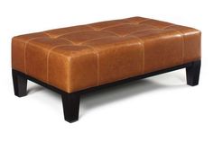 a brown leather ottoman sitting on top of a wooden table