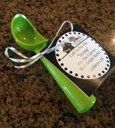 a green measuring spoon sitting on top of a counter next to a tag that says,