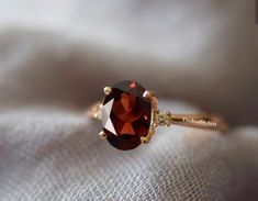 a close up view of a ring with a red stone on the top and side