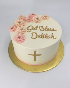 a white cake with pink flowers on top and the words god's blessing written on it