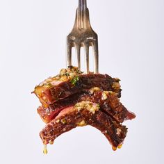 a fork with some meat on it and sauce coming out of the top one end