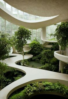 the interior of a modern building with plants growing in it and curved walkways on both sides