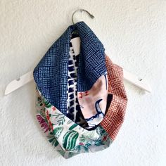 three scarves hanging from a hook on a wall