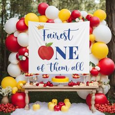 an apple themed first birthday party with balloons and desserts on the table in front of it