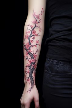 a woman's arm with pink flowers on it and a tree in the background