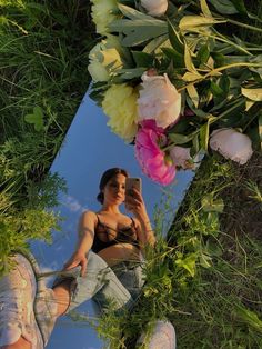 a woman taking a selfie in the grass with flowers on her head and legs