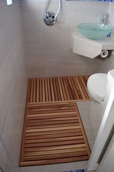 a bathroom with a wooden mat on the floor