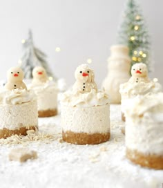 there are many small cakes with frosting on the top and snowmen in the middle