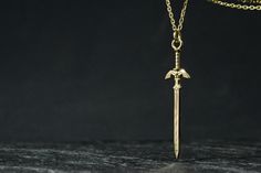 Legend of Zelda Necklace 14K Solid Gold Master Sword Zelda Jewelry Zelda Cosplay Jewelry This eye-catching 14K Solid Gold Master Sword necklace is carefully designed to fulfill all the expectations for a perfect Zelda jewelry piece. Either you simply love it, want to make a gift to someone you care for, or just looking to expand your fan based jewelry collection, as always this necklace is made to last and be loved! Pendant: 14K Solid Gold Chain: 14K Solid Gold Sword dimensions: 9.5x38mm Chain Length: 18 inches or 45cm  Chain link dimension: 1x2mm1 The sword has polished surface, as you can see from photos.  Also if you would like the sword can be with matte surface, like last photo. Please send me a message if you like the matte surface. All items come gift boxed to ensure they arrive saf Zelda Necklace, Zelda Jewelry, Zelda Cosplay, Cosplay Jewelry, Solid Gold Chains, Make A Gift, Legend Of Zelda, Chain Link, Gold Chain