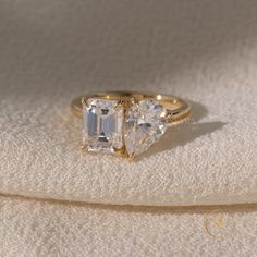 three stone ring sitting on top of a white cloth