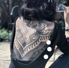 a woman with tattoos on her back sitting down