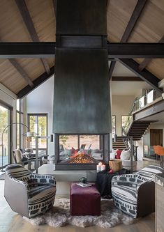 a living room filled with furniture and a fire place in the middle of a room