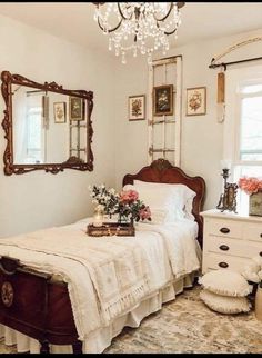 a bedroom with a bed, dresser and chandelier hanging from it's ceiling