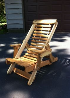 a wooden lawn chair sitting on top of a blue patio floor next to a garage