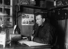 an old photo of a man sitting at a desk