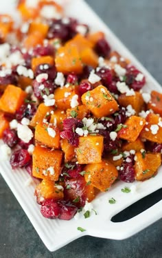 a white plate topped with carrots and cranberries covered in feta cheese