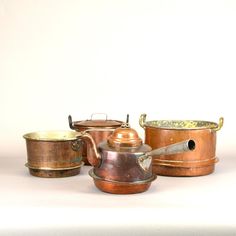 an assortment of pots and pans on a white surface