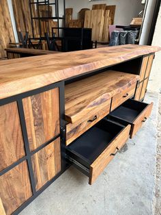 a large wooden cabinet with drawers on it's sides and black metal handles, in a warehouse