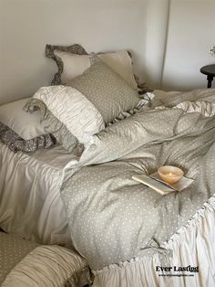 a bed that has some pillows on top of it and a book in the middle