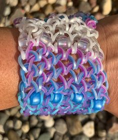 a close up of a person's hand wearing a bracelet with beads on it