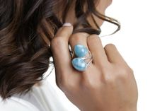 Enjoy the new collection of double stone rings is now out and about! Check these state of the art creations from one of our greatest artisans. Two stones Larimar rings so creatively made and with so much love for you to enjoy and maybe, just maybe show off a little :)  The marvelous blue Avaya Larimar ring reminds us of the beautiful and calm waters of our South beaches. Wear it and your hands will transport you to seas of tranquility. Make it yours!– Material: Larimar gemstone and 925 silver– W Fusion Style Oval Blue Jewelry, Elegant Larimar Rings For Anniversary, Adjustable Larimar Jewelry For Anniversary, Fusion Style Blue Sterling Silver Rings, Blue Sterling Silver Fusion Rings, Elegant Blue Ring With Natural Stones, Blue Larimar Jewelry For Anniversary, Larimar Gemstone Jewelry For Wedding, Elegant Handmade Larimar Jewelry