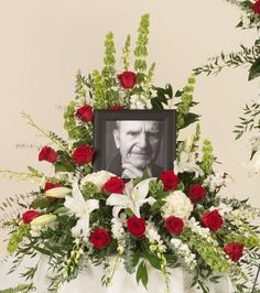 a memorial arrangement with flowers and a photo