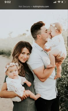 a man and woman holding two babys in their arms