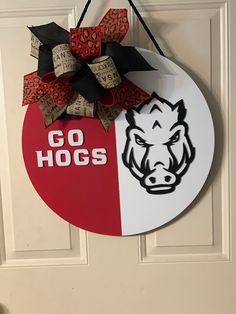 a door hanger with the word go hogs on it and an image of a boar's head