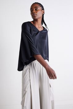 A black batwing style top features wide, flowing sleeves that drape elegantly for a relaxed yet stylish silhouette, perfect for an effortlessly chic look in any season. Its versatile design pairs well with pants or skirts, offering comfort and flair for different occasions. V-neckline Oversized sleeves Draped style Relaxed fit Casual Black Tops With Kimono Sleeves, Versatile Black Rayon Tops, Slouchy Cotton Batwing Sleeve Tops, Oversized V-neck Versatile Blouse, Versatile Oversized V-neck Blouse, Relaxed Oversized Batwing Sleeve Tops, Versatile Black Viscose Blouse, Elegant Oversized V-neck Top, Oversized Versatile V-neck Blouse