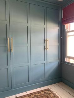 an empty room with blue painted cabinets and a rug on the floor in front of it