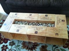 several wine boxes stacked on top of each other in front of a black couch and rug