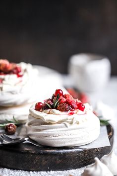 two desserts with white frosting and strawberries on top are sitting on a plate