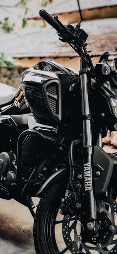 a black motorcycle parked in front of a building