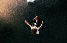 an aerial view of two people standing in the water