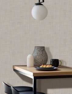 a dining room table with a plate of food on it and a vase hanging from the ceiling